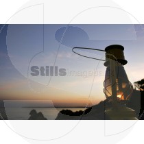 Oil lamp on the cliff at sunset